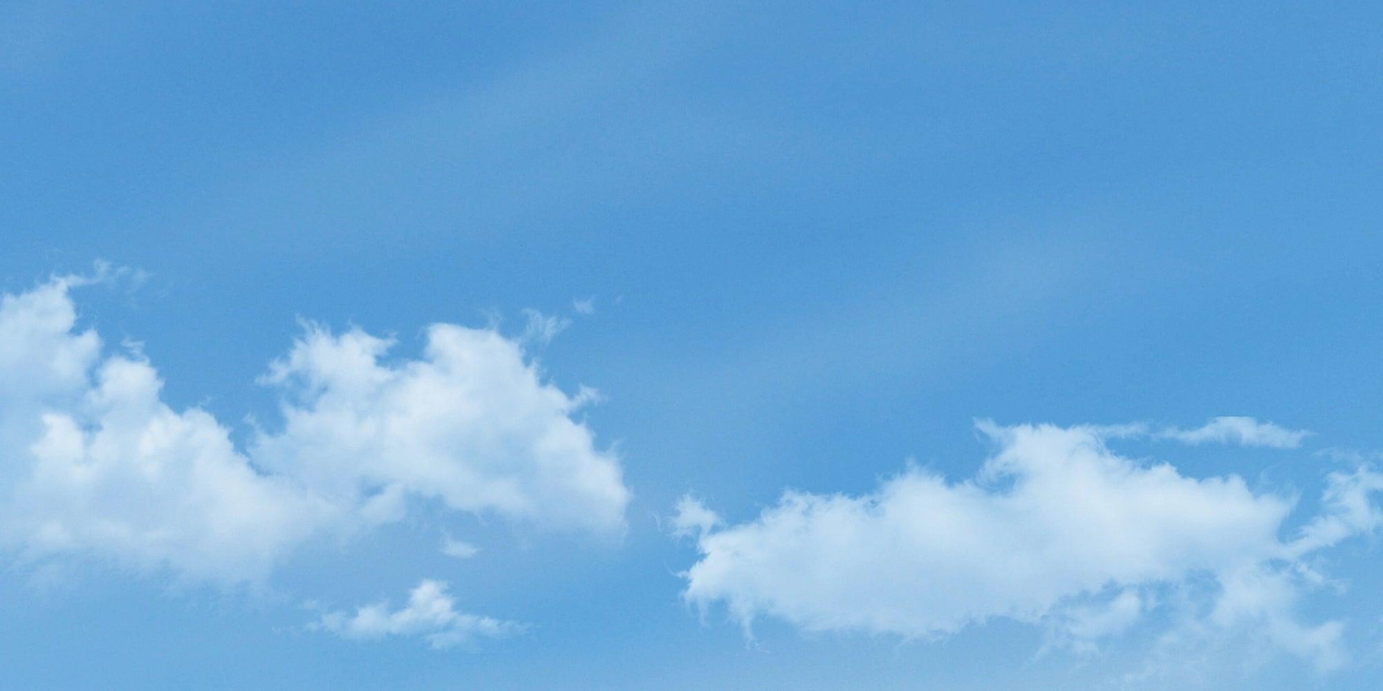 A clear blue sky with a few wispy white clouds scattered across it.